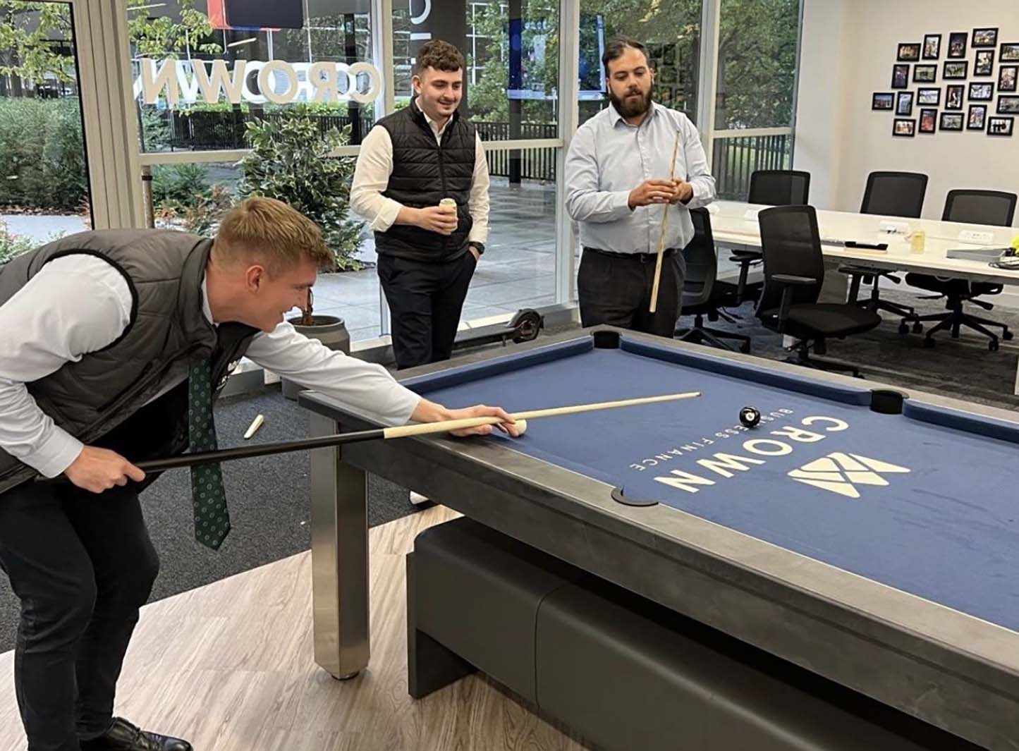 men playing pool on a table with logo printed onto cloth