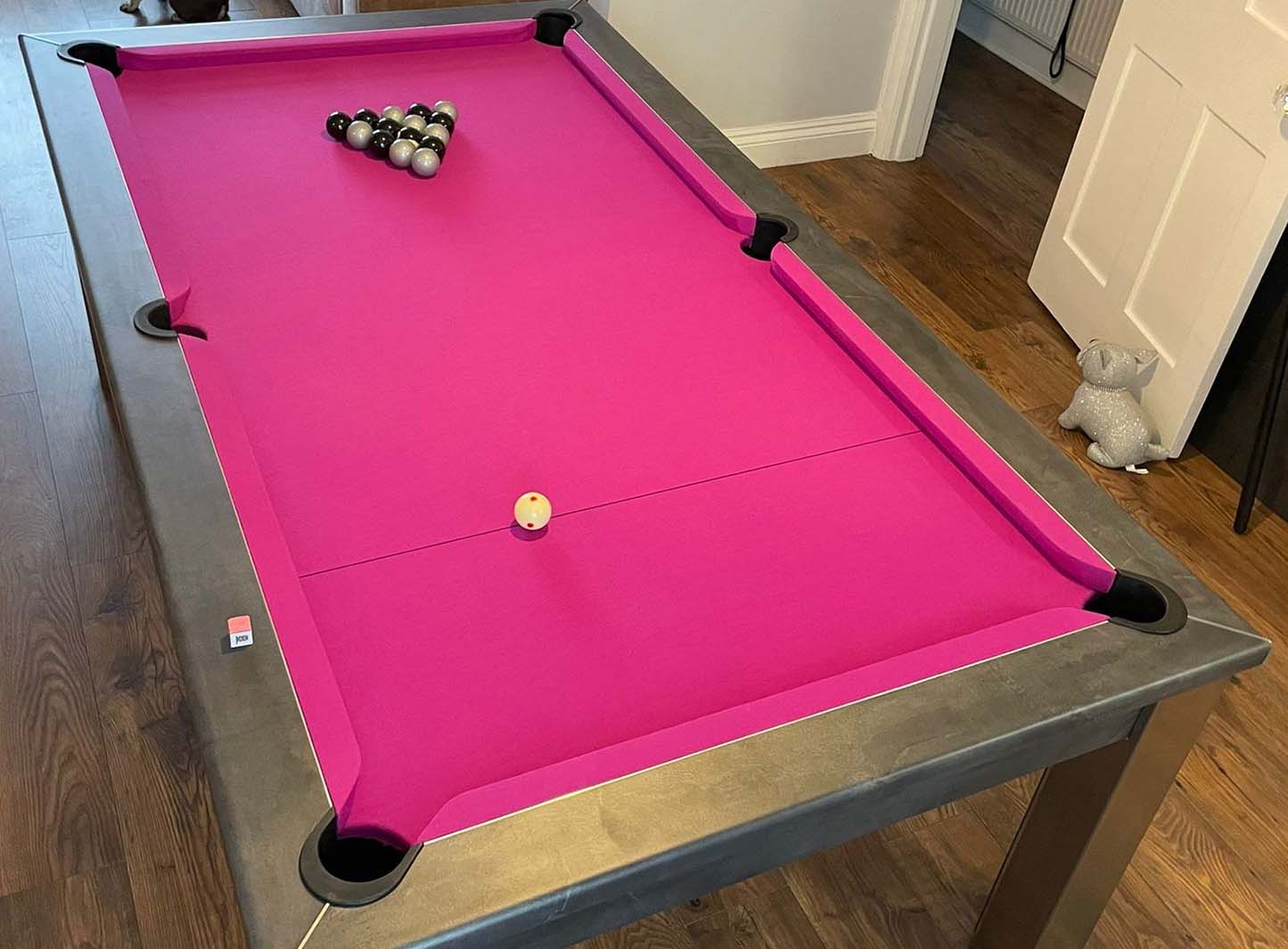 Silver and black pool balls and pink cloth felt