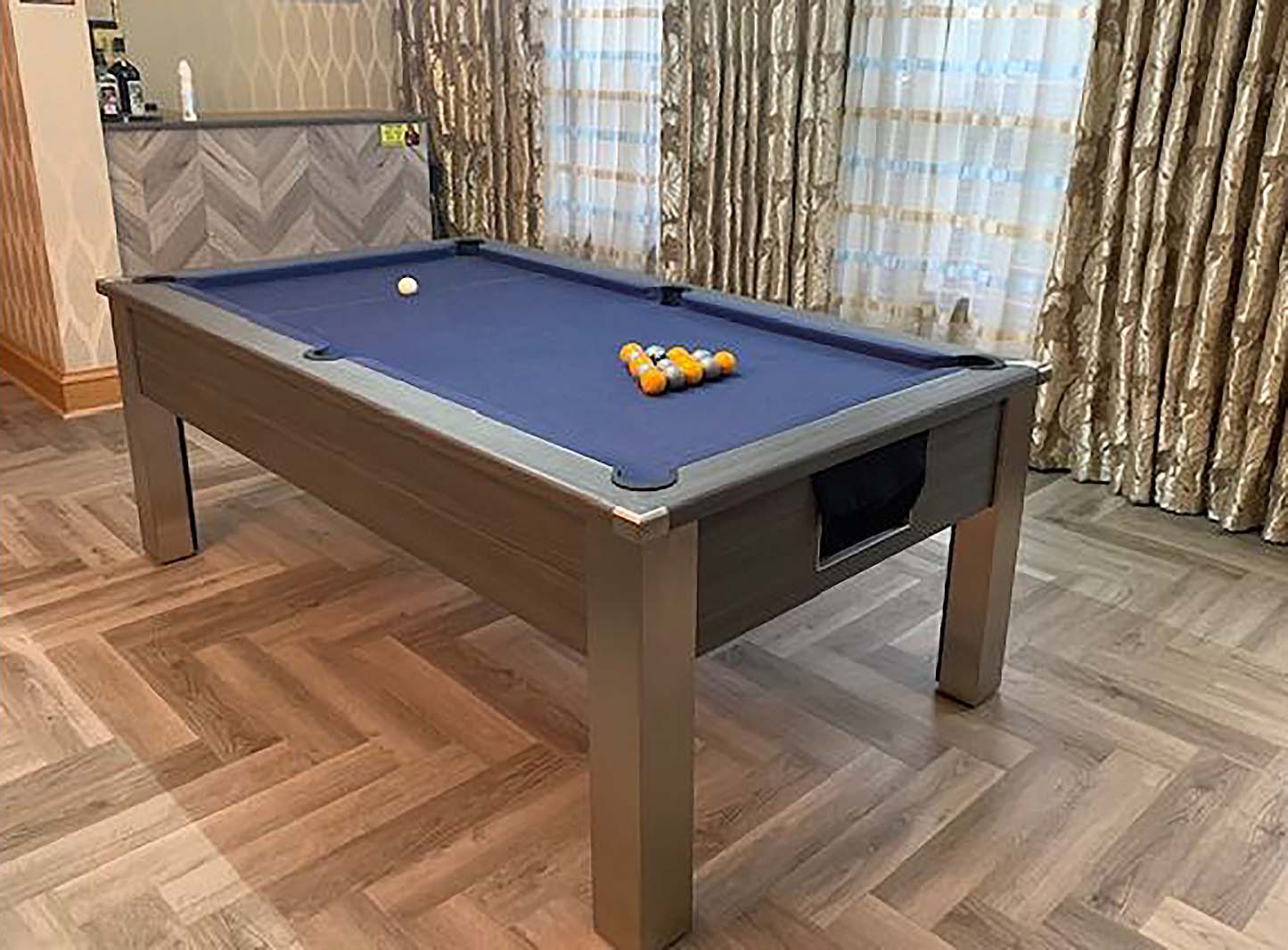 games room with a bar and pool table with blue cloth