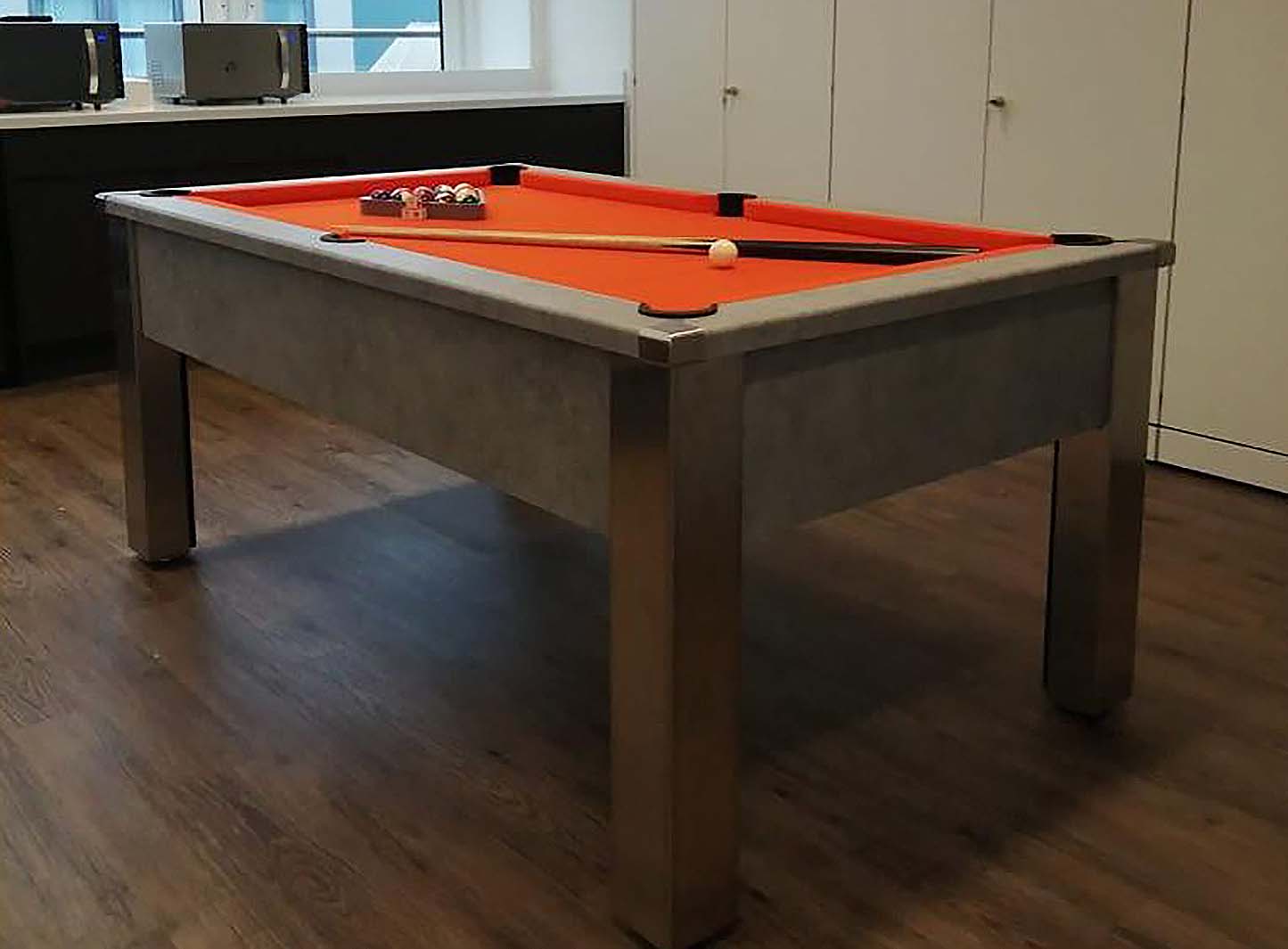 dark grey concrete style pool table in a games room with orange cloth