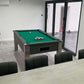 games room in a green theme with a pool table and bar with dark grey stools