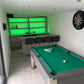 games room in a green theme with a pool table and darts board and bar with dark grey stools