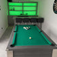 games room in a green theme with a pool table and darts board and bar with dark grey stools