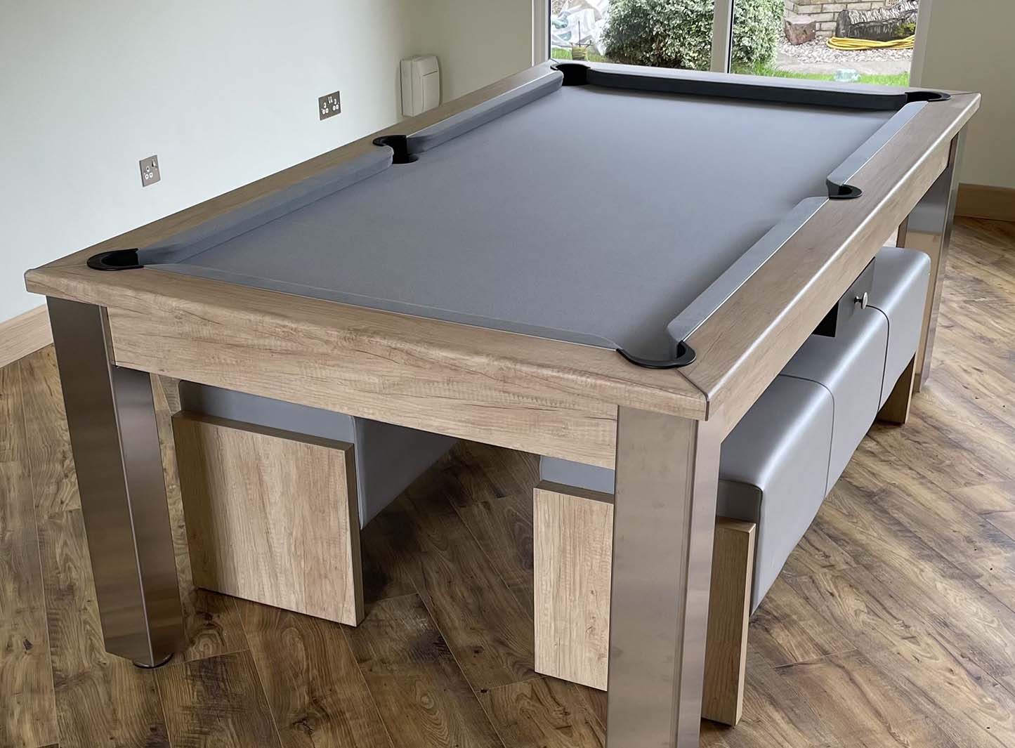 Pool table with grey cloth and matching banches doubles up as a dining table