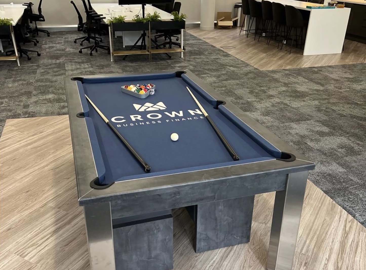 Pool table with dark bluc cloth and white logo