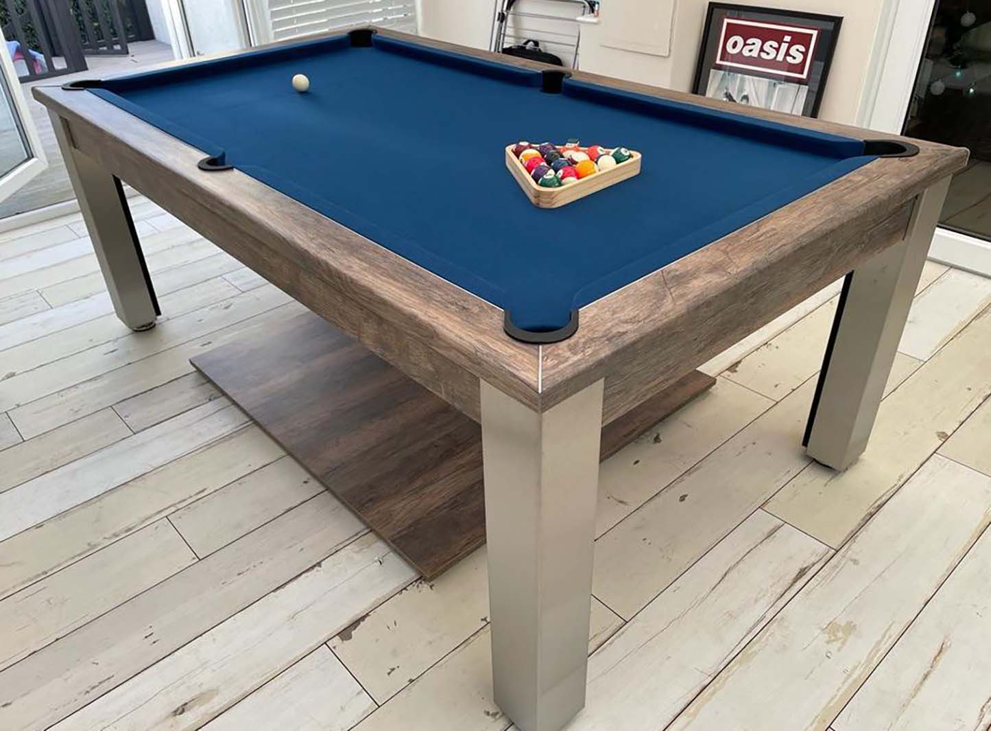 Mid blue cloth pool table in a rustic games room