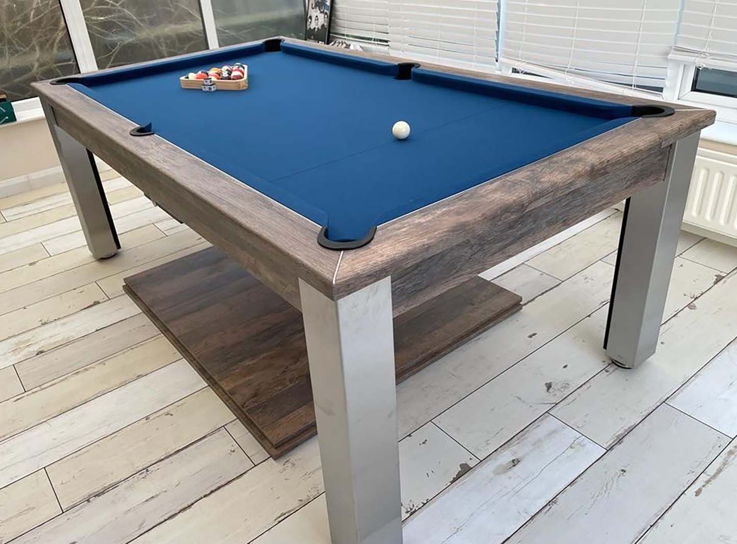 Mid blue cloth pool table in a rustic games room