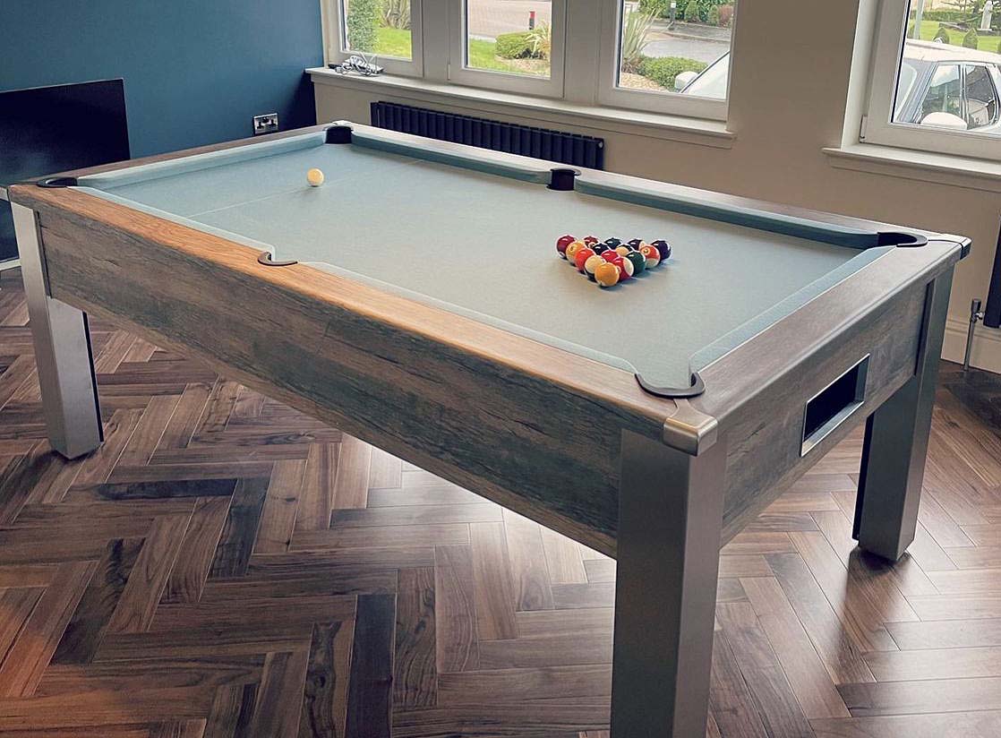 Distressed oak framed pool table with spots and stripes balls and light green cloth