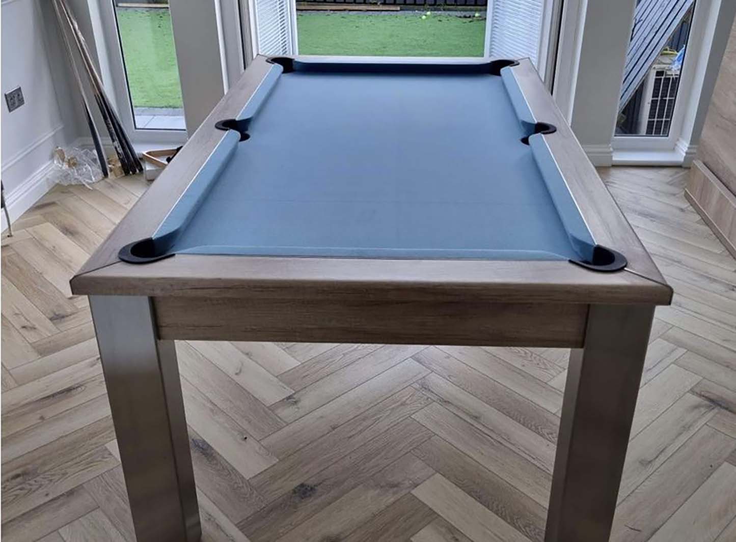 Pool table with grey cloth and matching banches doubles up as a dining table