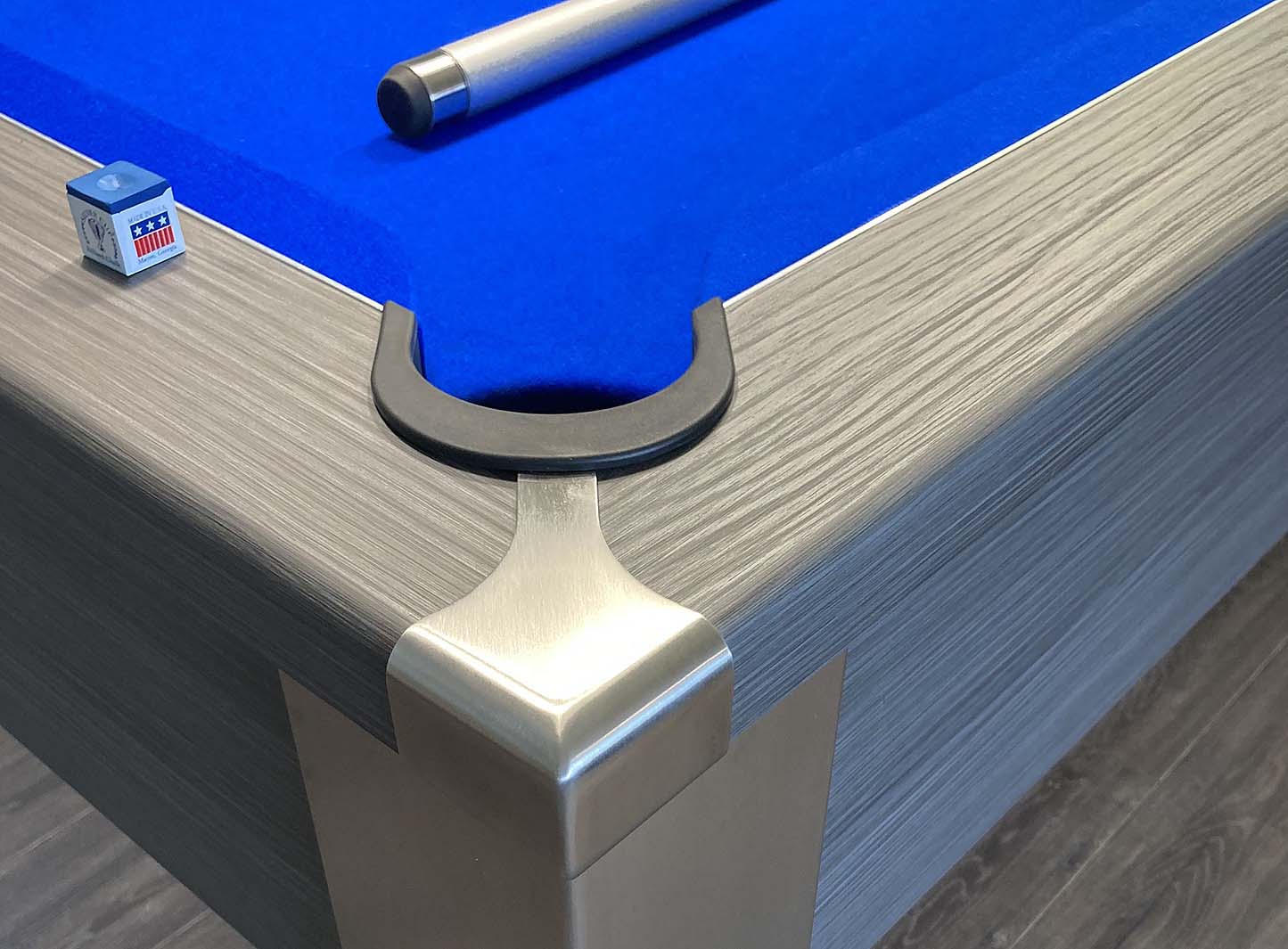 high quality stainless steel corner pocket protector on a grey pool table with royal blue cloth