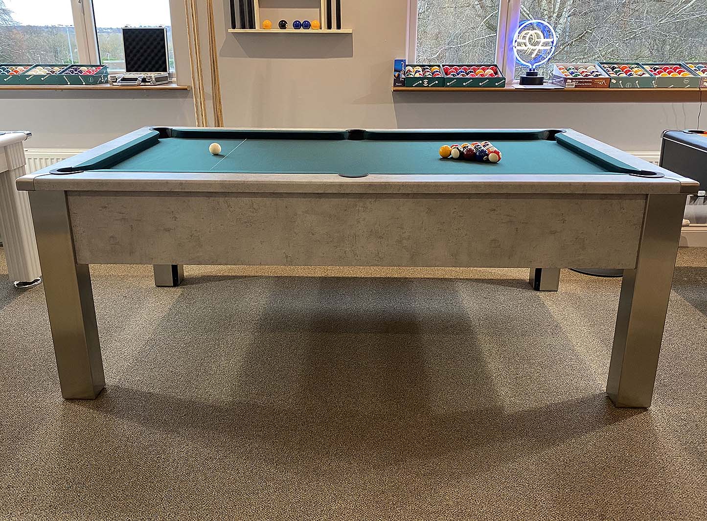 side view of a grey pool table with a green cloth setup ready to play